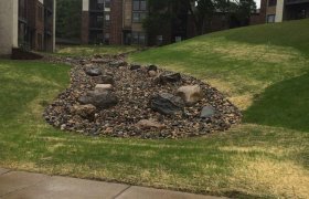 Completed rock drainage ditch between multiple apartment complexes