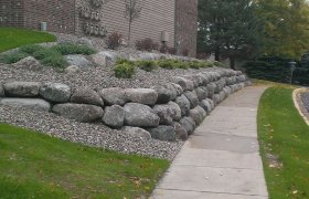 Rock garden landscape on a commercial property running along side a sidewalk
