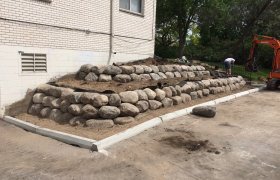 Newly finished, multi-tiered boulder retaining wall