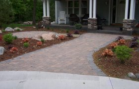 Paver walkway connecting the front entry of a house to its driveway