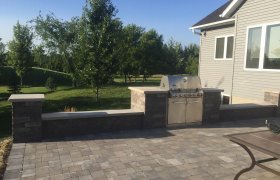 Backyard paver patio with retaining wall block sitting wall and built in grill surround