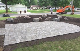 Curved paver patio with a rock garden landscape next to it