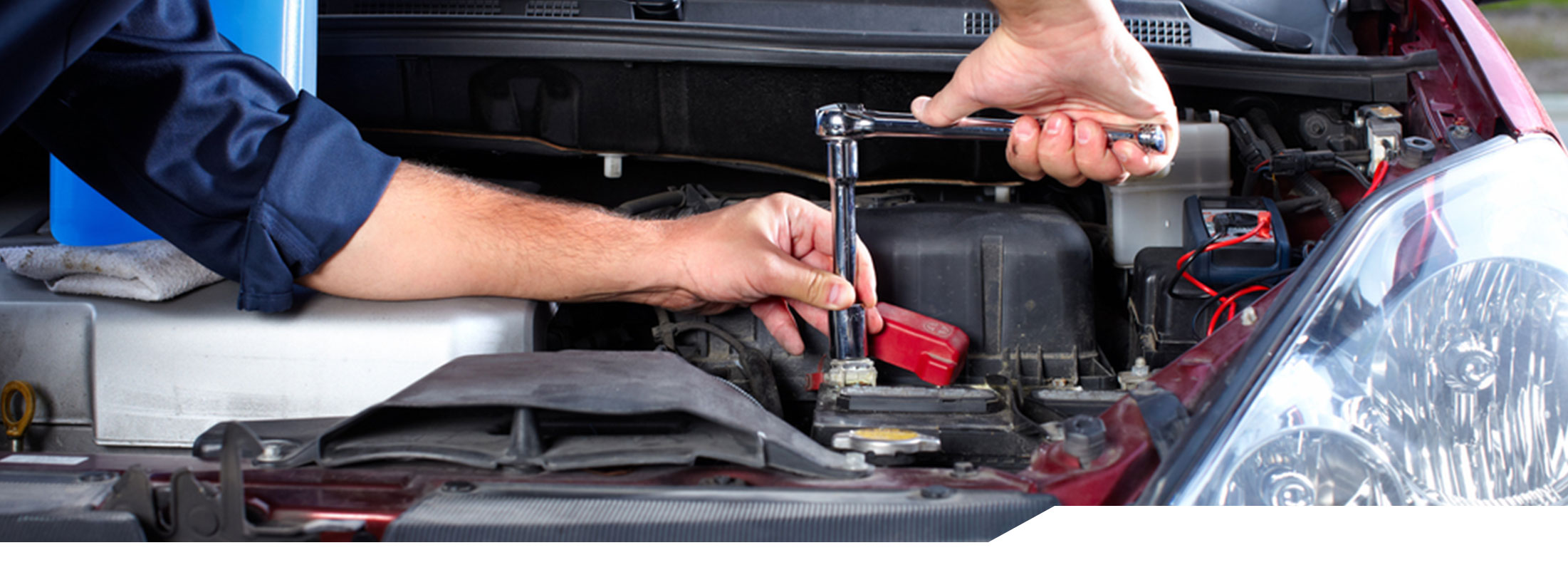 Auto mechanic working under the hood of a vehicle