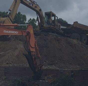 Two excavators and a dump truck working on a job site