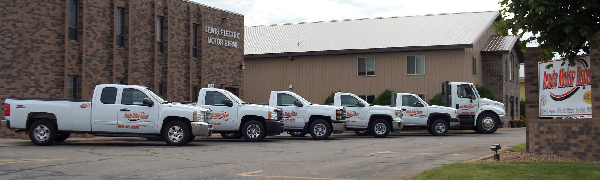 Row of company vehicles in front of Lewis Motor Repar in Waite Park, MN